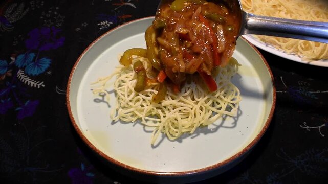 pouring hot vegetable gravy on crispy fried noodles to prepare classic chopsuey or chopsy. homemade restaurant or street style food that is much better than ouside.