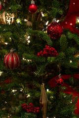 Natural Christmas Tree With Red and Gold Decorations. Christmas Tree Branch Close-Up With Red and Gold Decor
