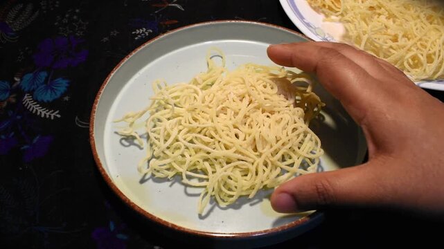 putting homemade crispy fried noodles on plate for food preparations.