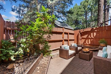 In the backyard, theres a lovely patio with chairs and a table