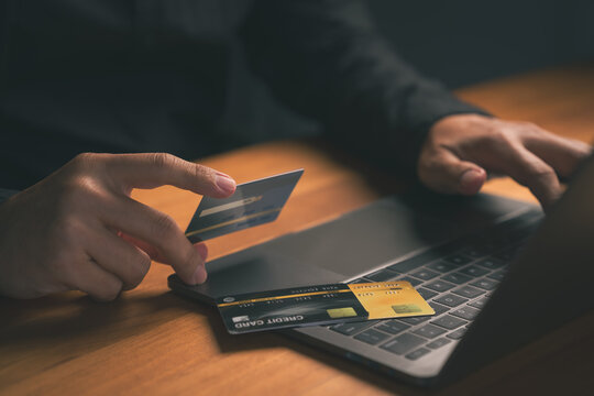 Person using a credit card with a laptop, representing digital banking, financial transactions, pay off the credit card, and secure internet shopping technology. Online payment and e-commerce concept.