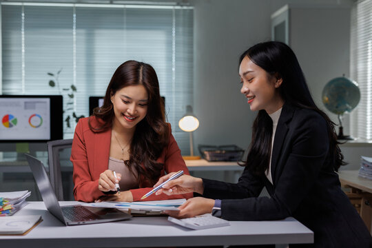 Businesswomen collaborating on project, discussing financial data - Powered by Adobe