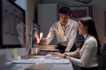 Professionals analyzing user interface designs on computer at night