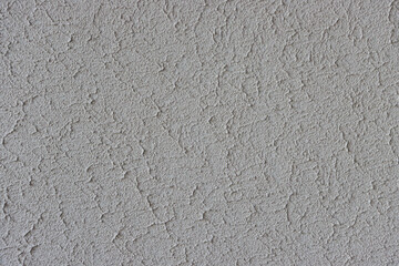 Close-up texture of old, uneven, rough grey plaster.