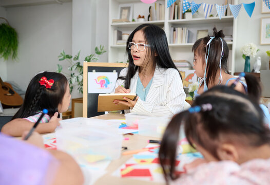 A teacher and children engrossed in an educational activity. The setting is a classroom or play area, designed to encourage learning and creativity