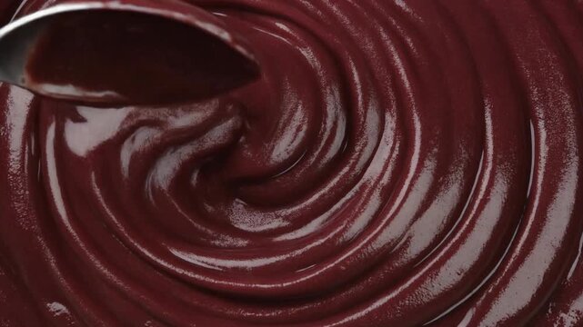 Stirring creamy Brazilian acai puree in a bowl close up.