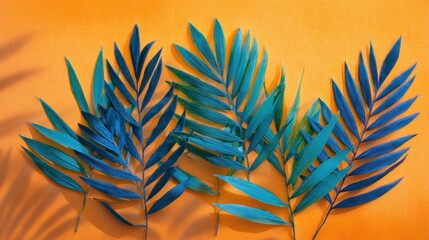 Blue and green tropical leaves on an orange background with shadows.