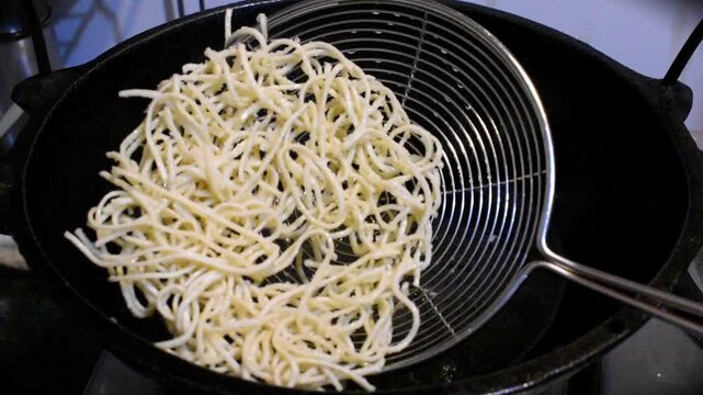 taking out fried noodles for oil.