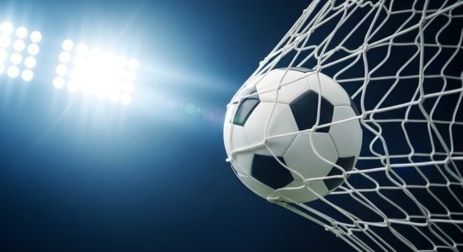 Soccer ball hits the net under bright stadium lights during a game