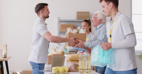 Volunteers group providing healthy and appropriate food to people in need, sort meal to prepare its distribution in box, giving access to healthful food, making positive impact in helping community 