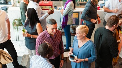 Diverse group socializing at a casual gathering. People chatting, enjoying drinks. Relaxed...