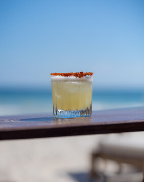 Refreshing Margarita cocktail on a beachside table.