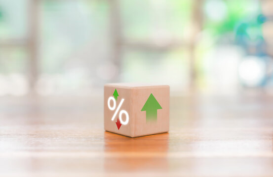 A wooden block with percentage and directional arrows symbolizing interest rate changes, financial growth, investment trends, and market fluctuations, ideal for economic, banking, and business-related - Powered by Adobe