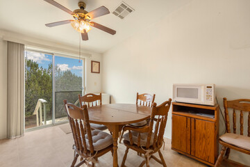 A wellarranged dining room with a table, chairs, and ceiling fan