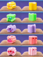 Close-up of a company of small, fun figurines of monsters in the form of puzzles, arranged on a wooden podium
