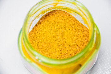 raw Curcuma powder in transparent container, medical spicy aroma, glass jar, plastic bag, isolated on white background, studio shot photography, selective focus, shallow depth of field, Cairo Egypt