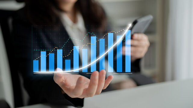 Business professional holds smartphone displaying a digital growth graph, symbolizing success and innovation in financial analysis and strategic planning. Impute - Powered by Adobe