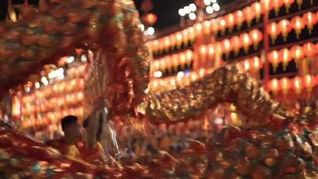 A vibrant golden dragon dances during a festival, illuminated by warm orange lights.