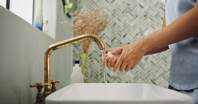 Water, soap and woman washing hands in bathroom for removal of germs, dirt or bacteria. Sink, hygiene and female person with cleaning skin for health, wellness or virus safety routine in home. - Powered by Adobe