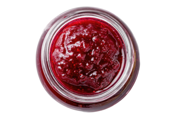 Close-up view from above of a glass jar filled with red berry preserve
