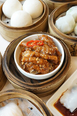 Noodle rolls and Braised Sichuan chicken feet served with Baozi in wooden basket, Steamed bun...
