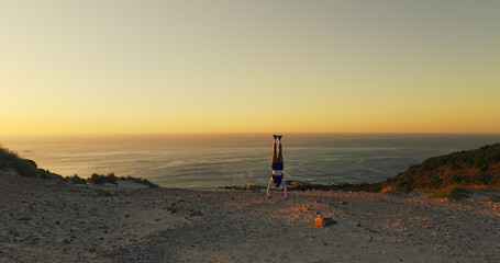 Aerial view, handstand and horizon with man outdoor at ocean for exercise, fitness or hiking hobby....