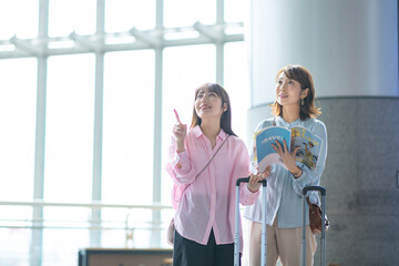 Obraz premium 旅行雑誌を見る女性