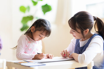 お絵描きをする園児と保育士