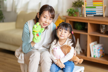 パペットを持った保育士と園児のポートレート