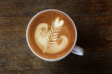 a cup of latte art coffee on wooden background                                                                      