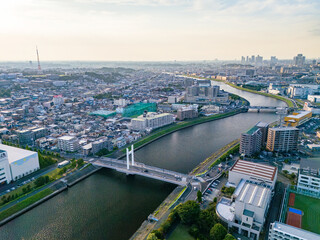 Fototapeta premium 川面に映る夕陽。鶴見川のドローン撮影。 西に横浜市鶴見区、東に川崎市川崎区、幸区がある。 河川工事前の調査のため許可をもらって飛行している。 神奈川県横浜市鶴見川-2025 