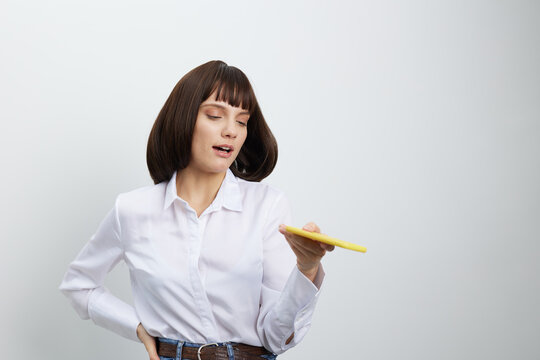 A professional woman stands in a bright, neutral space, holding a yellow marker and gesturing, conveying confidence and focus for teaching, presenting, or creative instruction in a clean studio - Powered by Adobe