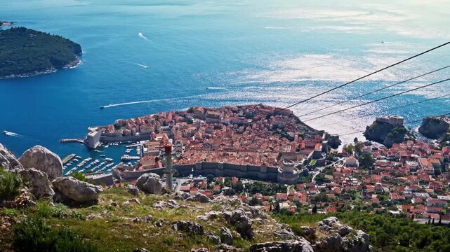Wide-angle landscape view from Mount Srđ captures Dubrovnik&rsquo;s Old Town with terracotta rooftops, historic streets, and the deep blue Adriatic Sea stretching into the distance, highlighting the city