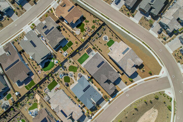 A house with two garage doors is in the middle of a dirt field