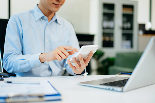 businessman working with digital tablet computer and smart phone with financial business strategy layer effect on desk in morning light