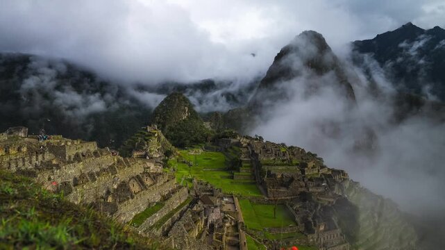 Machu Pichhu morning fog cloud movement Peru Per&uacute; time lapse ancient Inca temple ruin classic circuit two Hauny Picchu Mountain citadel structure tourists guided tour zoom in