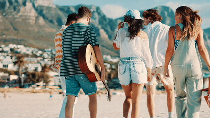 Walking, friends and group on beach for holiday break, summer travel or outdoor picnic for tourism. Guitar, weekend trip and people together for vacation to relax, back or connection for relationship