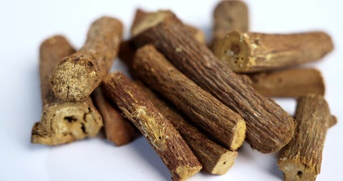 Ayurvedic Mulethi or Liquorice root stick or jeshthamadh powder served in a bowl over moody background