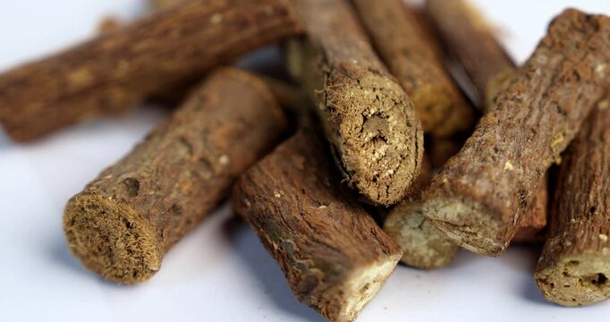 Ayurvedic Mulethi or Liquorice root stick or jeshthamadh powder served in a bowl over moody background