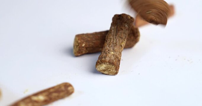 Ayurvedic Mulethi or Liquorice root stick or jeshthamadh powder served in a bowl over moody background