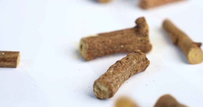 Ayurvedic Mulethi or Liquorice root stick or jeshthamadh powder served in a bowl over moody background