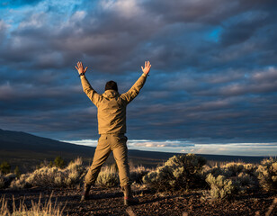 person waving both arms overhead in the universal distress gesture, standing alone