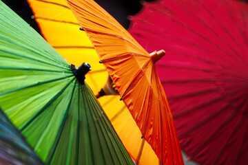 Vibrant Stack of Colorful Paper Lanterns and Umbrellas in Close-Up