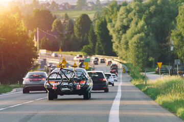 Carrying bicycle on back of vintage automobile