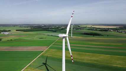 view of wind turbine among green fields and blue sky