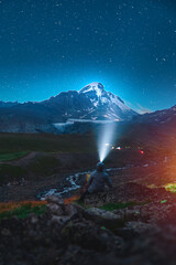 Hiker resting under night sky with stars