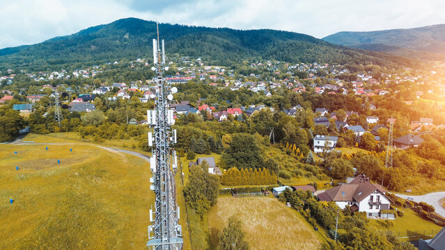 Telecommunication tower is transmitting a signal over the forest, providing broad mobile network coverage in a rural area