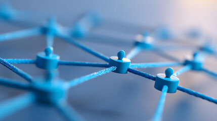 Close-up of interconnected blue pins linked by ropes forming a network structure, symbolizing connection, communication, and collaboration