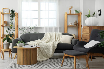 Interior of living room with black armchair, sofa and lamp