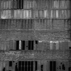 Diese Wand, gefangen in einem kontrastreichen Schwarz-Weiß, ist ein unendliches Muster aus Ziegeln...